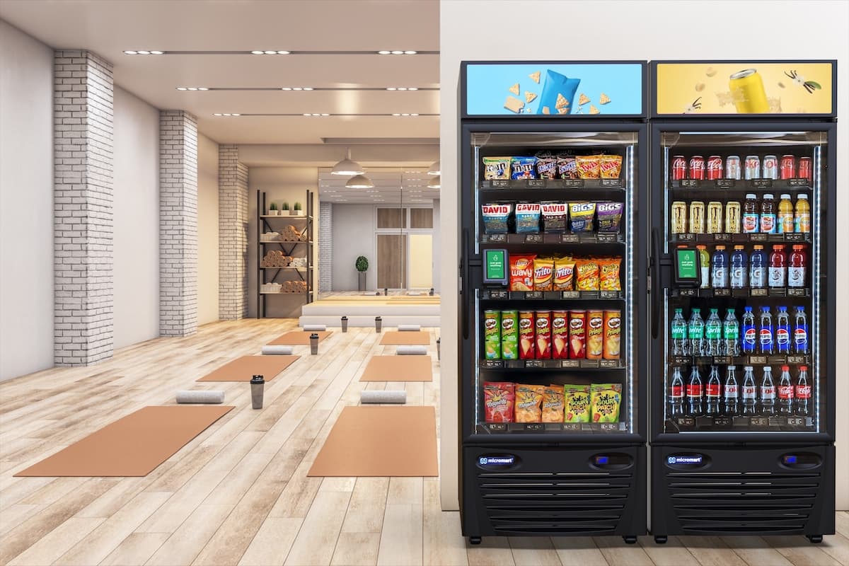 Two Smart Fridge™ cabinets stocked with snacks and drinks beside a yoga studio